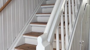 A staircase with white railings and wooden steps. - Charming half-timbered house in the heart of the city! "Fachwerkstube" (Witzenhausen)