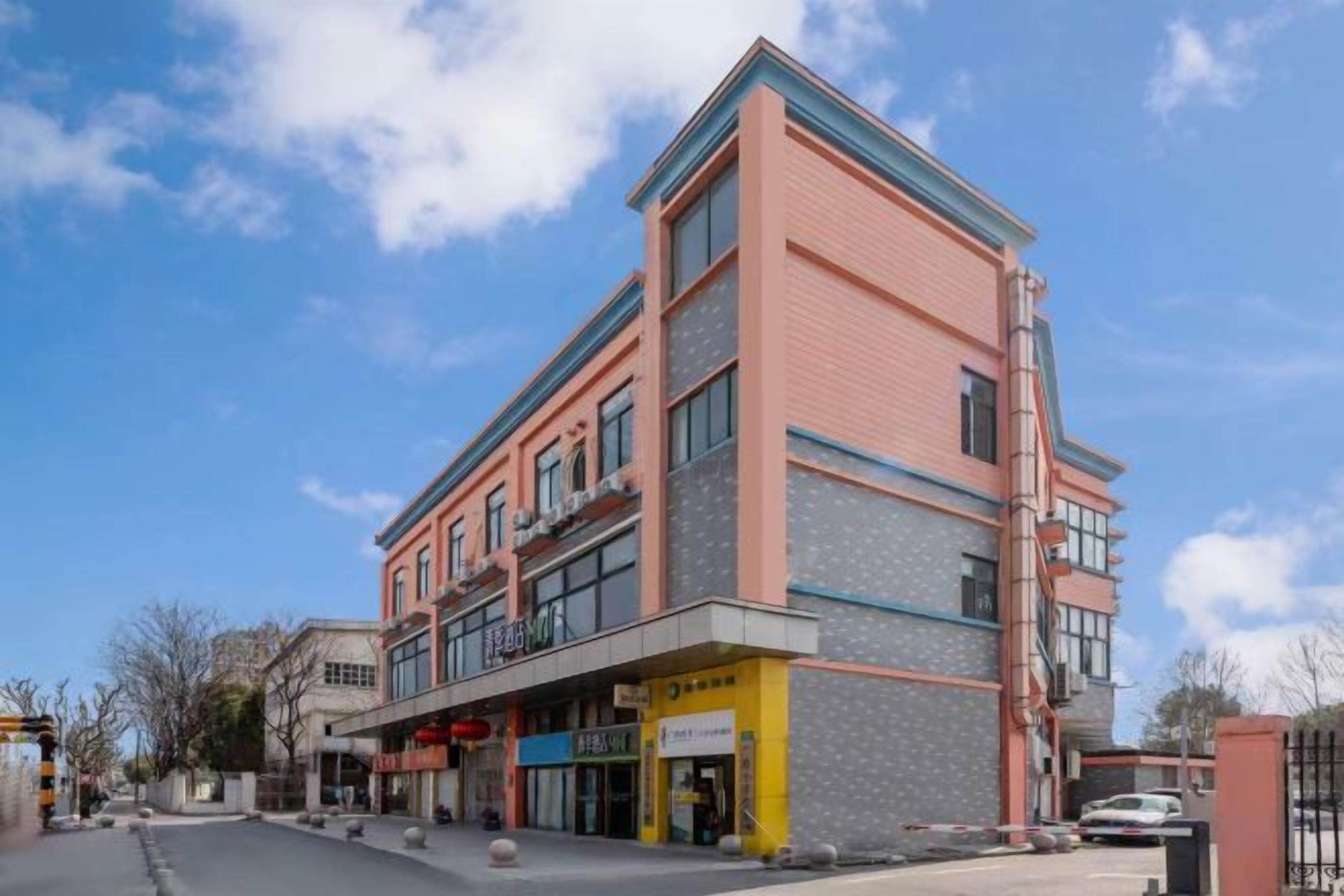 Ein mehrstöckiges Gebäude mit einer glatten Fassade, großen Fenstern und einem Eingang im Erdgeschoss.