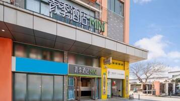Un hotel con fachada moderna, entrada visible y señalización que indica que es un hotel 'Mini'.