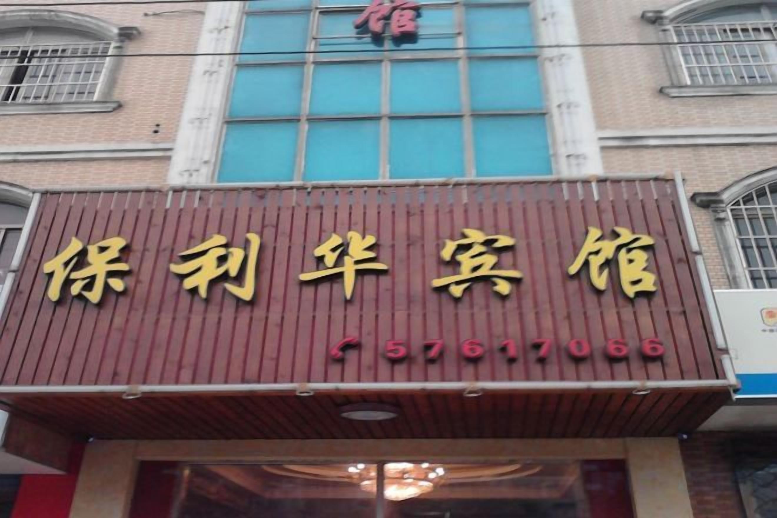 A hotel sign with Chinese characters and a phone number.