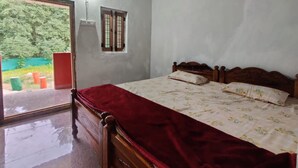 A bedroom with a wooden bed, a red bedspread, and a window with bars. - pickurstay vbss camping (Gangaraju Madugula)