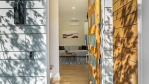 A hallway with a wooden door, a mailbox, and a wall-mounted light fixture.