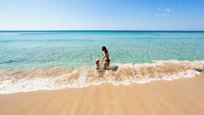 A beach scene with clear turquoise water and a sandy shore. - Sea & Sun Porto Cesareo (Porto Cesareo)