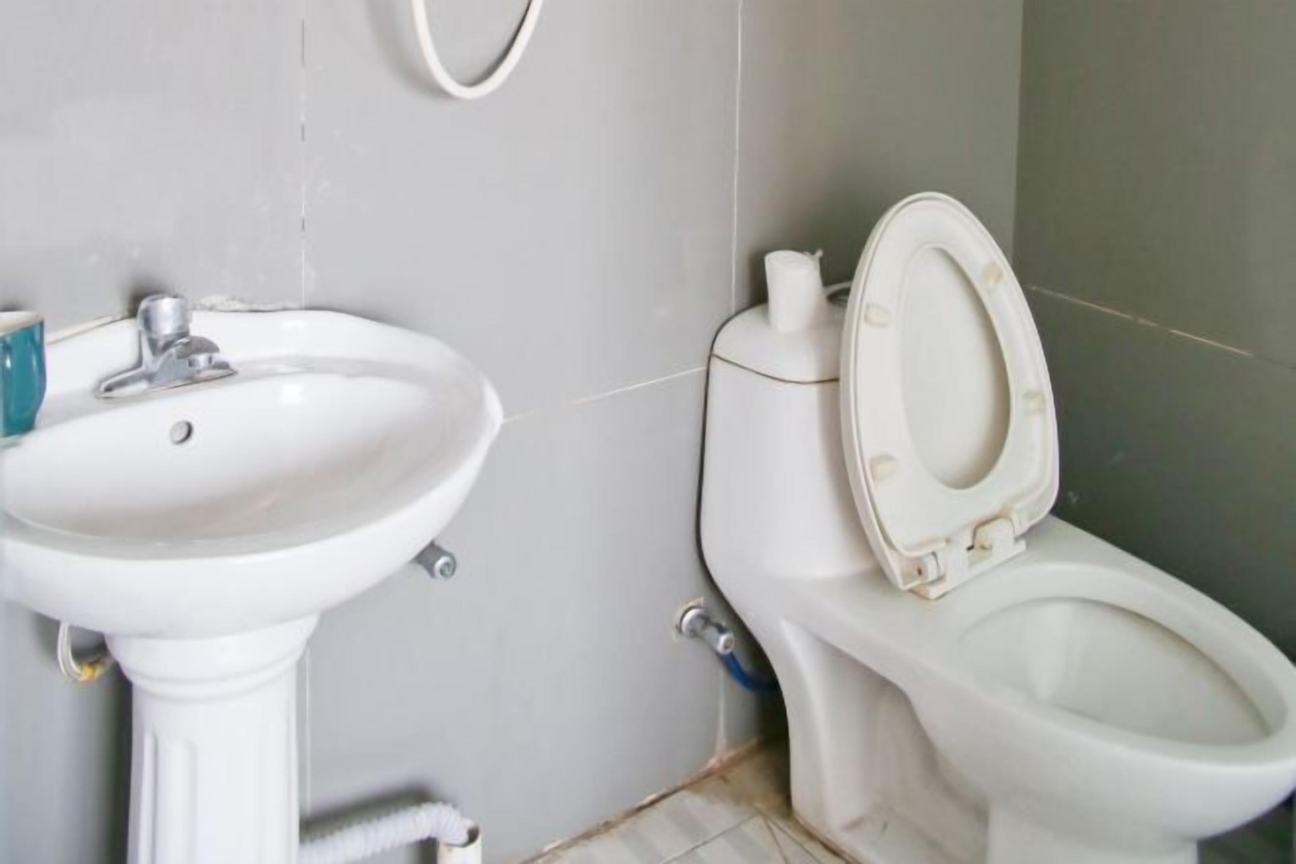 A bathroom with a white sink and toilet.