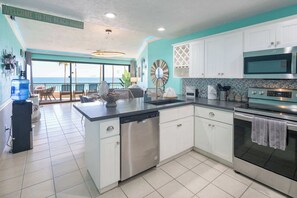 A kitchen with white cabinets, a dishwasher, an oven, and a large island.