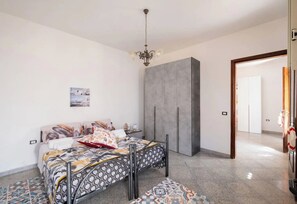 A bedroom with a bed, a wardrobe, a chandelier, and a patterned rug. - Chill e Relax Sul Mare (Nardò)