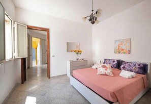A bedroom with a bed, a nightstand, a mirror, and a painting on the wall. - Chill e Relax Sul Mare (Nardò)