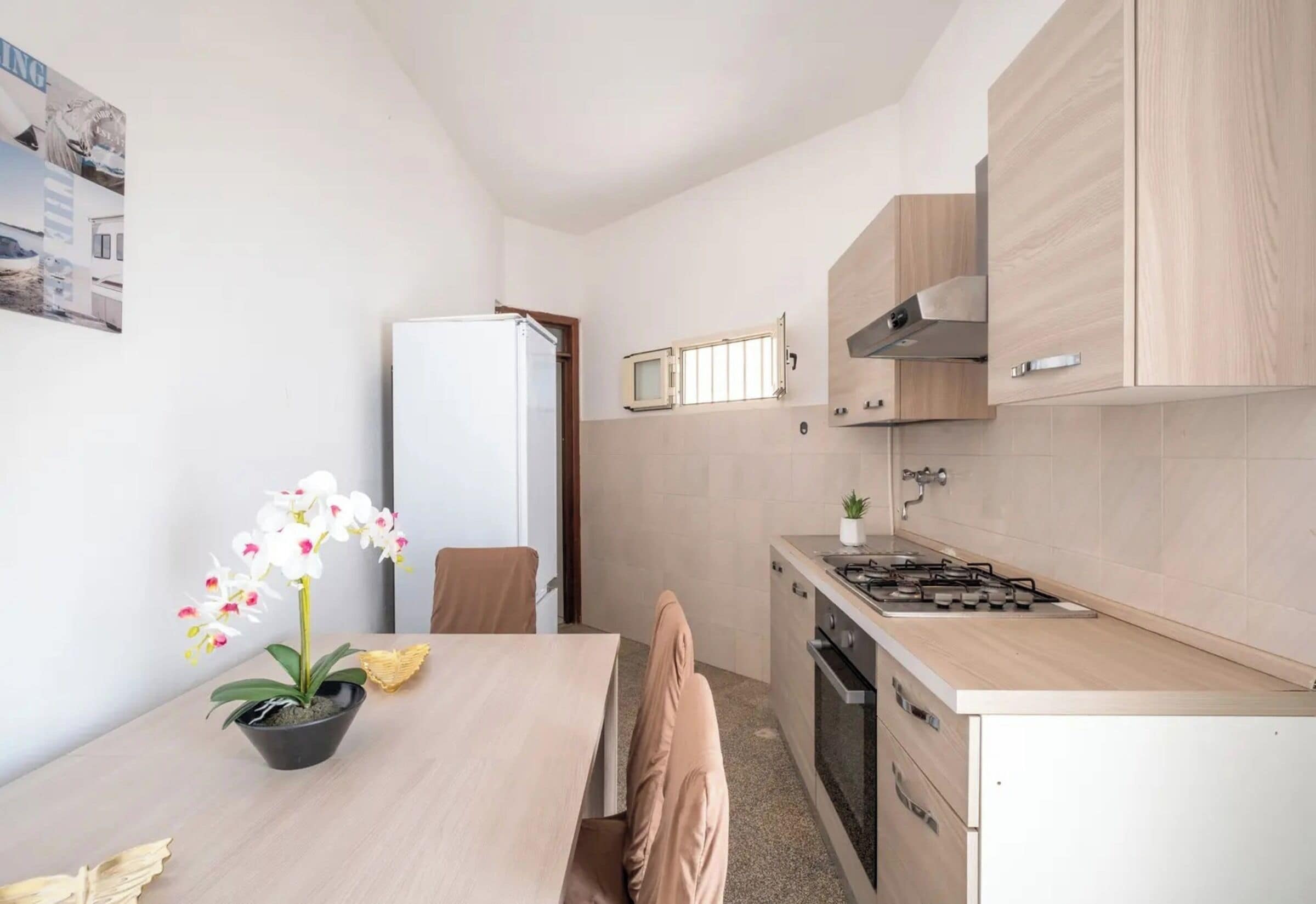 Cocina compacta con una mesa de madera, un refrigerador, un microondas y una estufa.