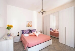 A bedroom with a bed, bedside tables, a dresser, a mirror, and a wardrobe. - Chill e Relax Sul Mare (Nardò)