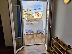 A room with a sliding glass door leading to an outdoor balcony with two chairs. - Holiferias NoStress Sal Island (Santa Maria)