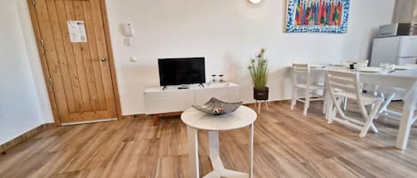 Departamento Confort, vista a la ciudad | Área de sala de estar | Televisión de pantalla plana de 80 cm con canales por cable