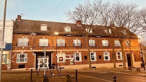 A two-story brick building with multiple windows and a door, likely a public building or office. - The Sneyd Arms Hotel (Stoke-on-Trent)