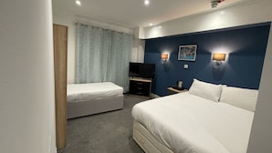 A hotel room with two beds, a television, a desk, and wall-mounted lamps. - The Sneyd Arms Hotel (Stoke-on-Trent)