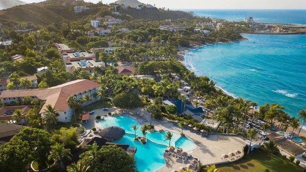 An aerial view of a resort with a large swimming pool, palm trees, and a beach. - Lifestyle Tropical Beach (Puerto Plata)