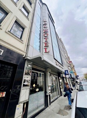 A hotel with a prominent sign, large windows, and a storefront with visible items. - Lal Hotel (Istanbul)