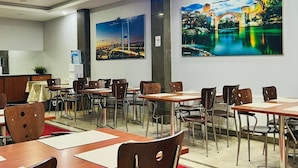 A restaurant with tables and chairs, a red carpet, and two large paintings on the wall. - Lal Hotel (Istanbul)