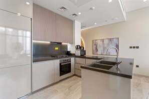 Una cocina moderna con electrodomésticos de acero inoxidable, horno empotrado e isla grande con pileta.