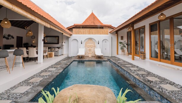 A pool area with a Buddha statue, seating, and a dining area. - Villa Niji - 3BR Villa with Pool Seseh (Munggu)