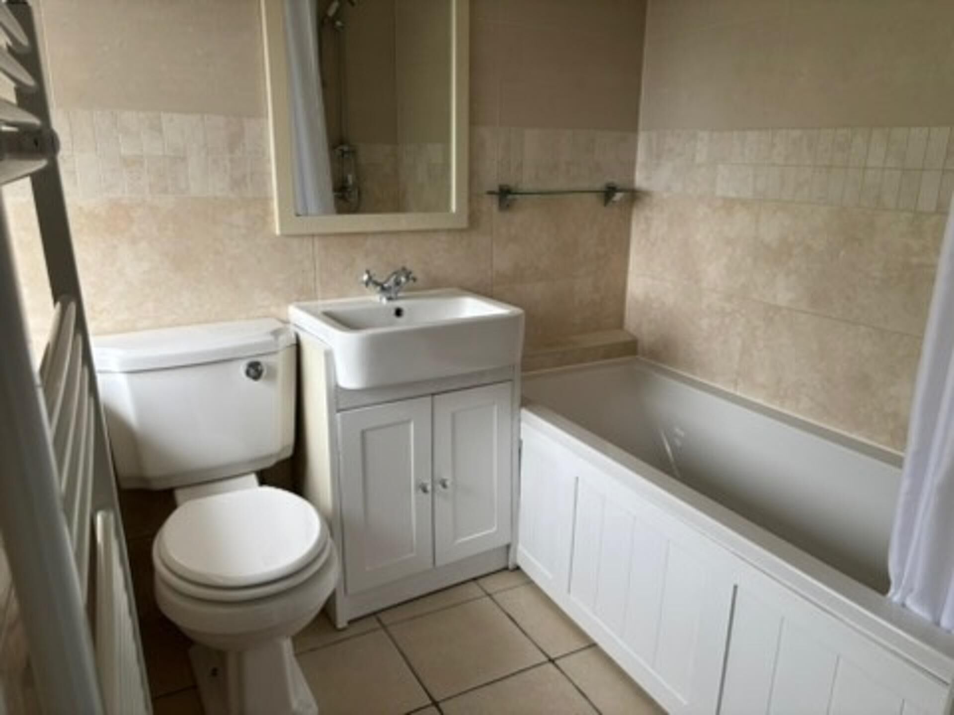A bathroom with a toilet, sink, and bathtub.