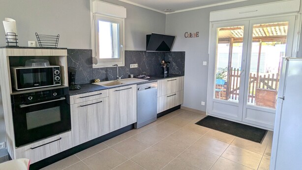A modern kitchen with a microwave, oven, sink, and dishwasher.