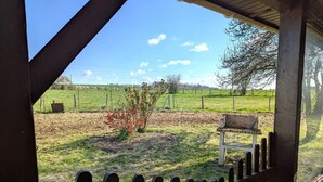 A wooden fence with a bench in a rural setting.