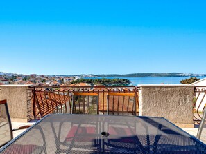 A terrace with a view of a coastal town and a body of water.