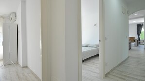 Una habitación de hotel moderna con una cama grande, un armario y una zona de estar con mesa y sillas.