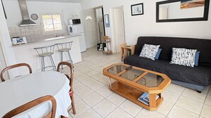 A compact living space with a kitchen, dining area, and a sofa. - Elegant modern villa steps from the beach (Biscarrosse Plage)