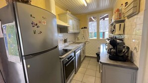 A compact kitchen with a refrigerator, oven, and a coffee maker on the counter. - Renovated villa near the lake, Biscarrosse (Biscarrosse)