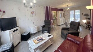 A living room with a TV, a white cabinet, a marble coffee table, and a red leather sofa. - Renovated villa near the lake, Biscarrosse (Biscarrosse)