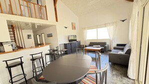 Amplia sala de estar con mesa de comedor, sofás y televisor.