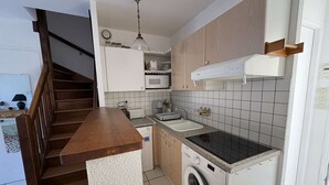 A compact kitchen with a wooden staircase, a washing machine, a microwave, and a sink. - Ideal setting near the ocean for 4 people in Biscarrosse Plage (Biscarrosse Plage)