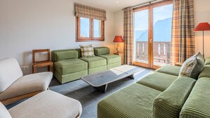 Ein Wohnzimmer mit einer Sofagarnitur, einem Couchtisch und Blick auf einen Balkon.