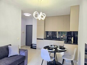 Een moderne keuken met een eethoek, een bank en een hanglamp.