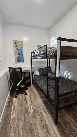 2 habitaciones, escritorio y tabla de planchar con plancha