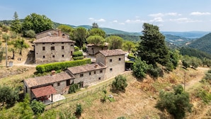 A stone building with multiple rooms, surrounded by greenery and hills. - Pet friendly apartment (Monte S.Maria Tiberina)