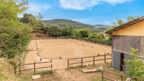 An outdoor equestrian arena with a wooden fence, surrounded by trees and hills in the background. - Pet friendly apartment (Monte S.Maria Tiberina)
