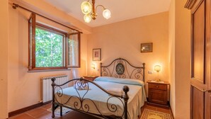 A bedroom with a bed, a window, a radiator, a nightstand, and a door. - Pet friendly apartment (Monte S.Maria Tiberina)