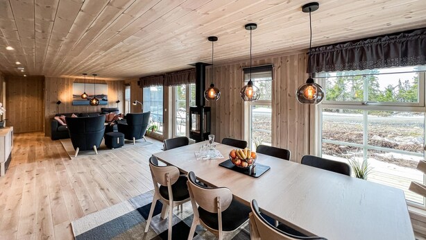 Une cuisine moderne dotée d’un îlot central, de planchers en bois et de luminaires suspendus.