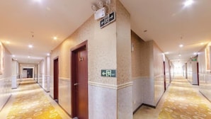 Un pasillo de hotel con piso estampado, una puerta y un letrero de salida de emergencia.