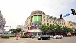 Un edificio de varios pisos con fachada curva, que muestra señalización para un hotel y un centro de negocios.