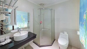 Un baño con ducha de vidrio, lavamanos blanco y retrete.