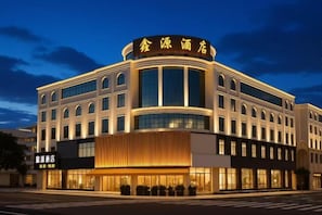 A modern hotel with a curved facade, large windows, and a prominent entrance. - Guangzhou Xinyuan Hotel (Huadu Shiling Branch) (Guangzhou)