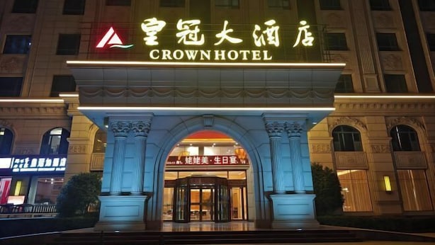 La façade de l’hôtel Crown, avec son entrée imposante et son enseigne lumineuse.