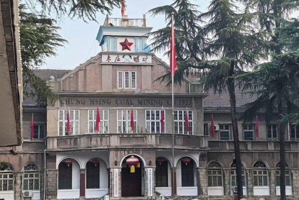 A building with a prominent red star and the name 'CHUNG HSI NG COAL MINING' on the facade.