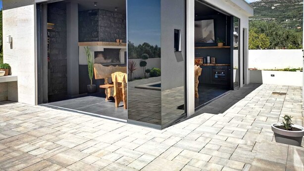 Una casa moderna con un amplio ventanal que da a un patio exterior.