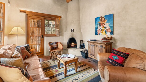Una sala de estar acogedora con sofás de cuero, una chimenea y un cuadro grande.