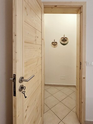 Enter a cozy space with a simple, functional design, featuring a tiled floor and decorative wall accents.