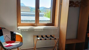 A room with a bed, a chair, a radiator, a window with a view, and a wooden wardrobe. - Charming, quiet town house with small garden  (Crest)
