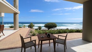 Eine Terrasse mit Tisch und Stühlen mit Blick auf den Ozean.